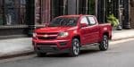 2018 Chevrolet Colorado red color park on road city background hd wallpaper